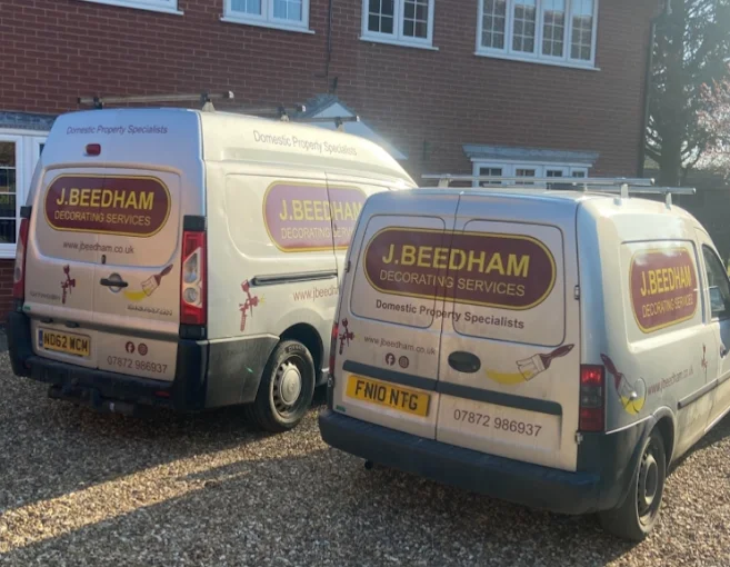 Two J Beedham Decorating Services vans parked on a driveway